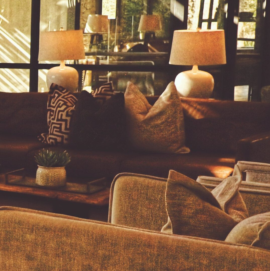 Elegant living room with velvet sofa, brass lamps and large windows