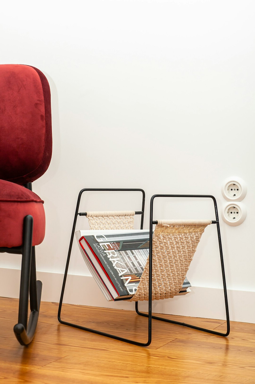 Cosy reading corner with a stack of magazines, a candle and a wool blanket