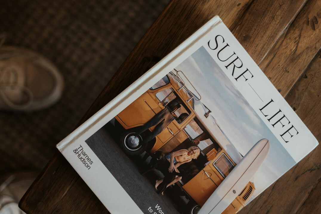 Editorial team of a lifestyle magazine gathered around a table with magazine layouts